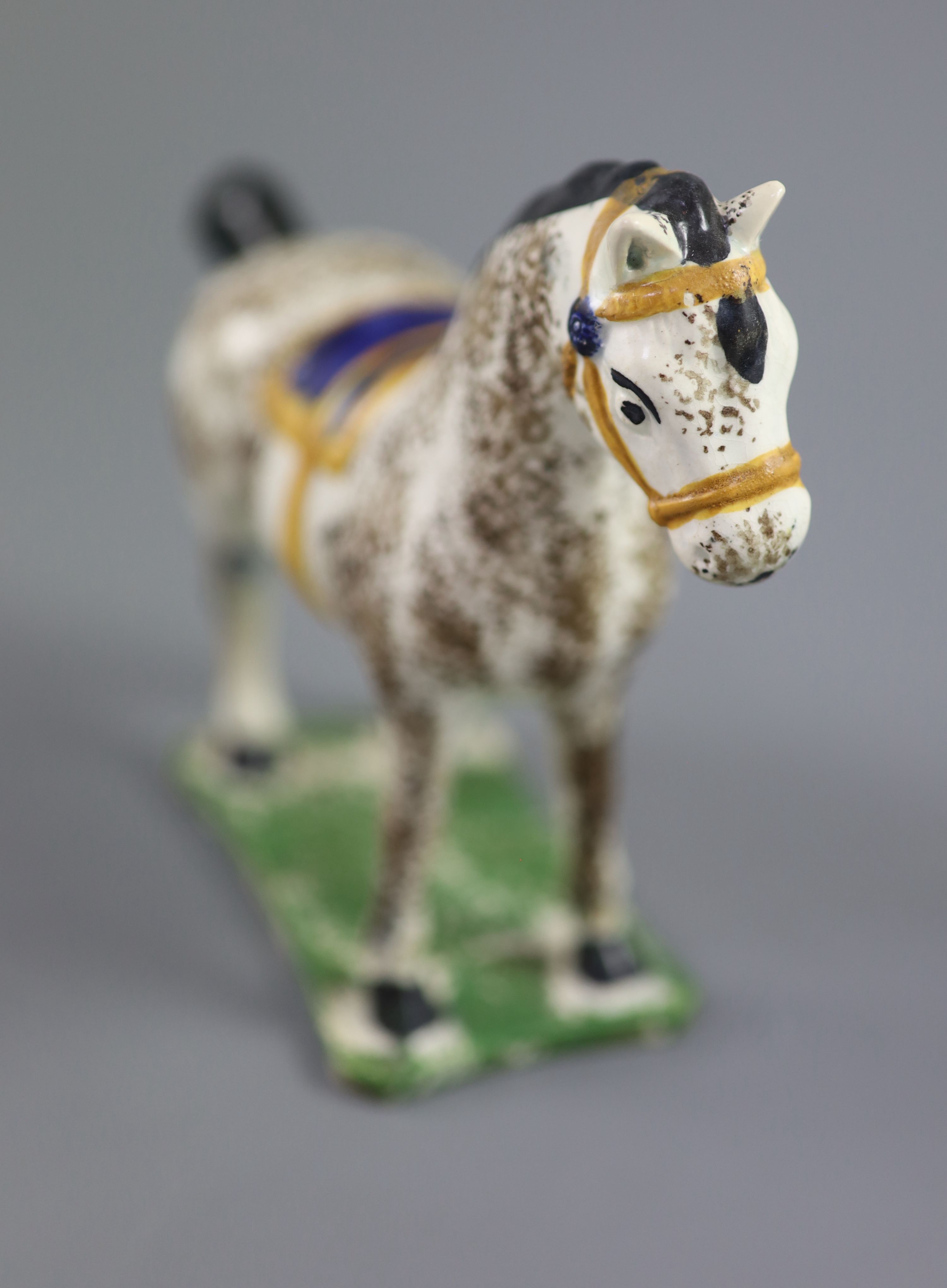 A North Country pearlware figure of a dapple horse with blue saddle, c.1800-20 14.5cm high